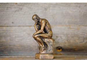 Sculpture of nude man sitting and thinking