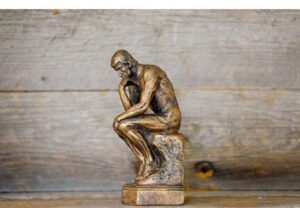 Sculpture of nude man sitting and thinking 