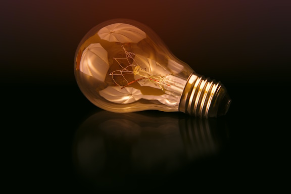 Closeup of an amber-tinted lightbulb on its side on a dark background