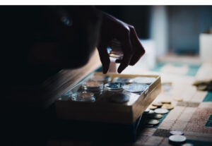 Hand putting or taking coins from a small wodden drawer