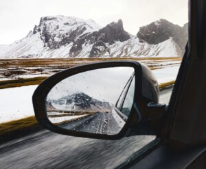 Winter mountain landscaoe seen in car side rearview mirror