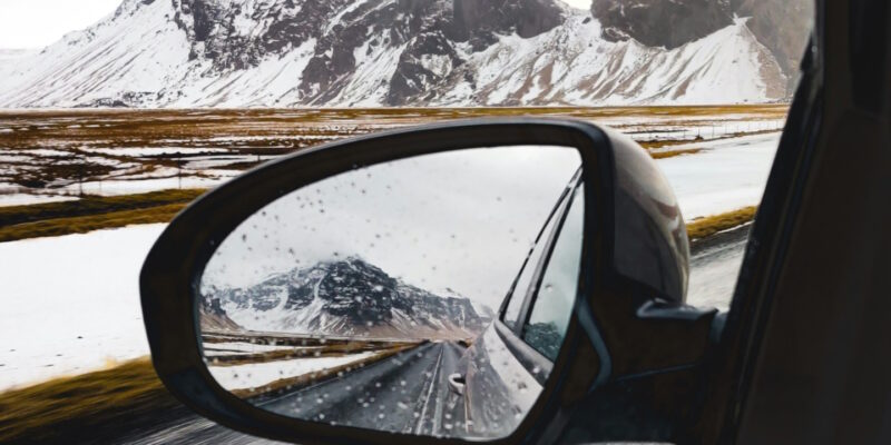 Winter mountain landscaoe seen in car side rearview mirror
