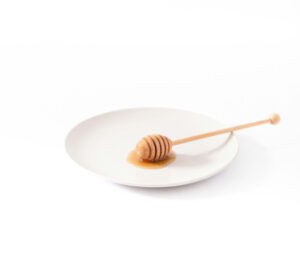 honey-dipped spoon resting on a plate; high switching costs lead to sticky business models