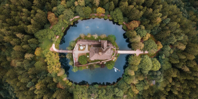 Bird's eye view of a Moat surrounding a castle in a forest