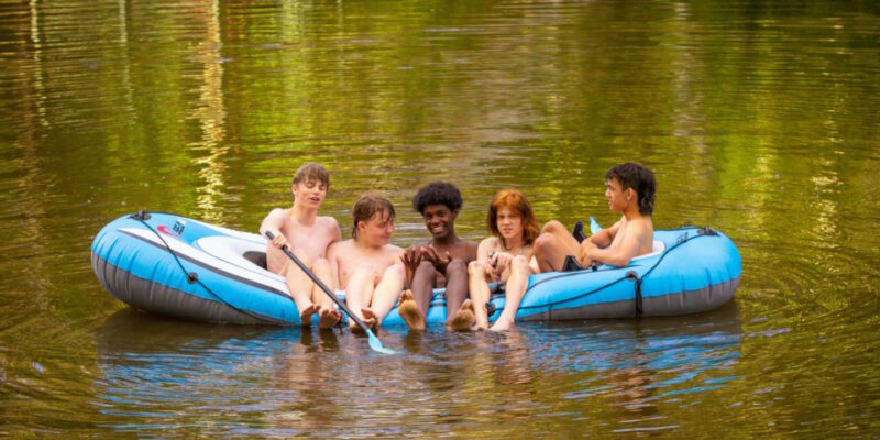 Five teenage boys in a dingy on a lake